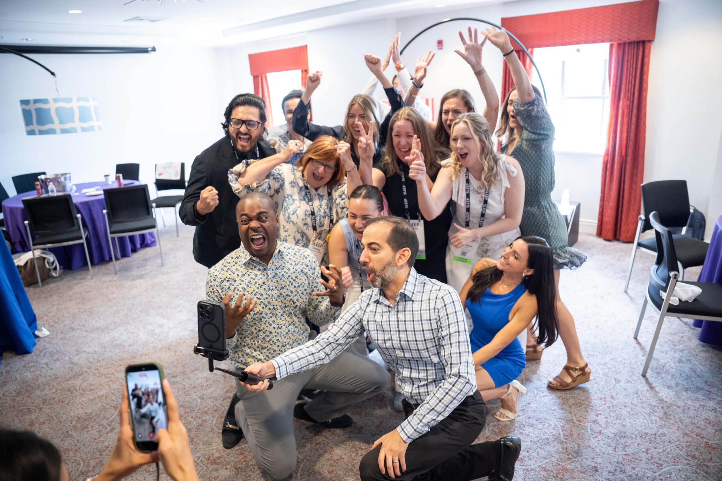 Sujay Kansagra, MD, holds a selfie stick, while Chris Allen, MD, poses next to him, with other attendees at a pre-SLEEP 2026 event.